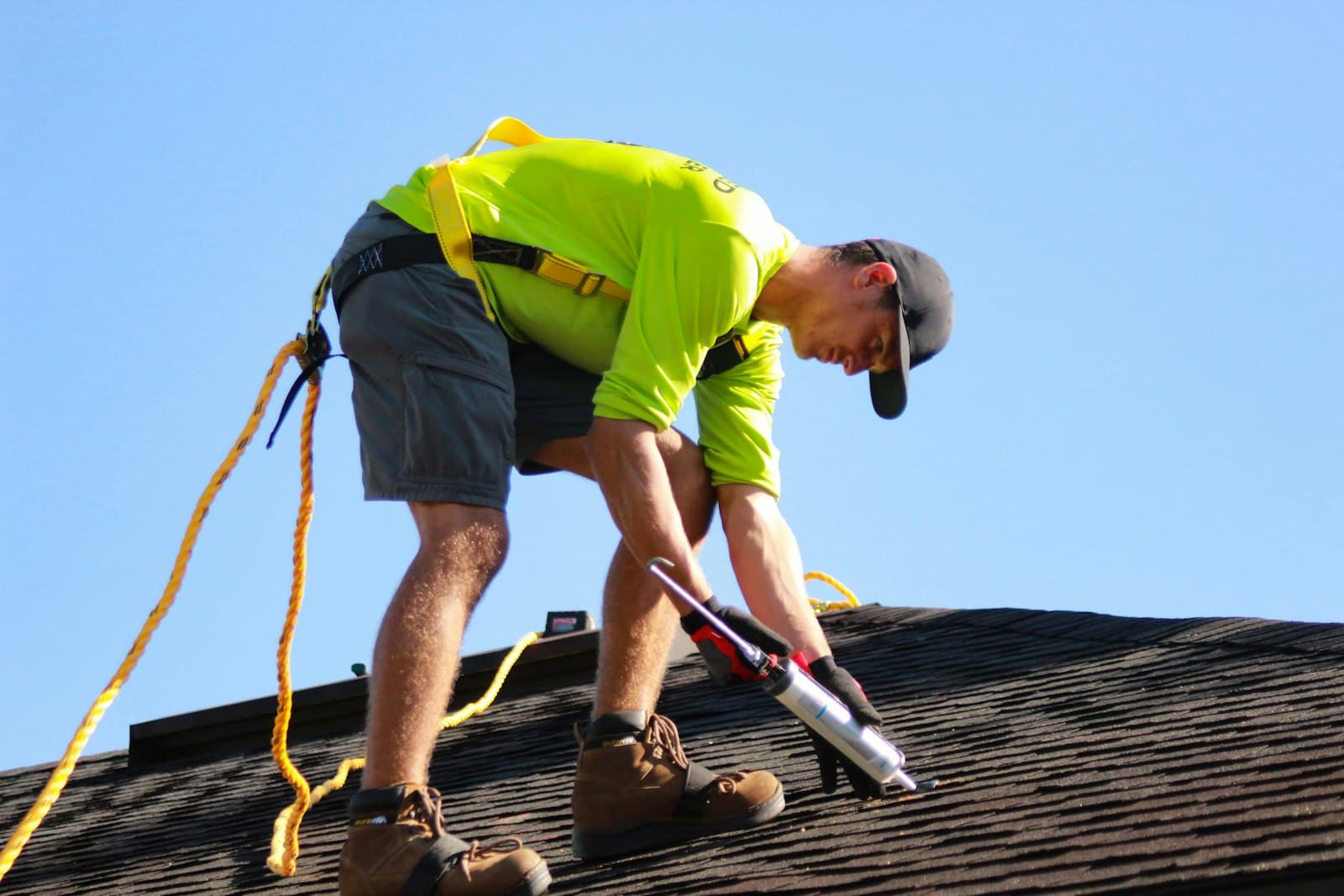 Roofer in a yellow shirt on a roof